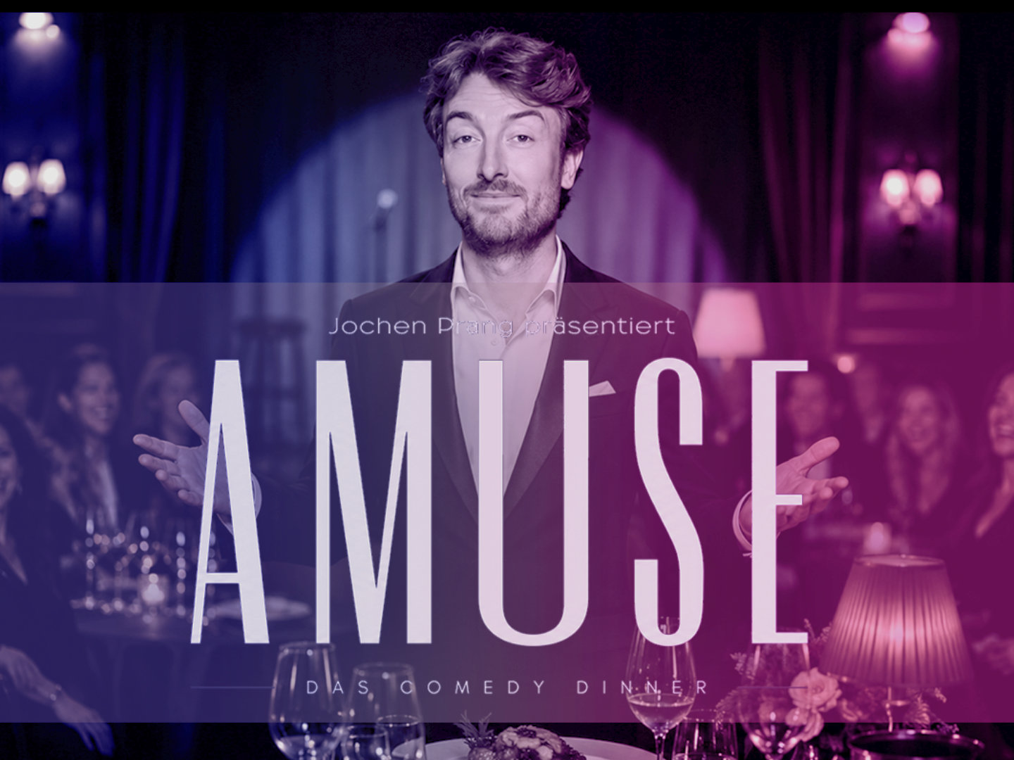 Jochen Prang steht vor Gästen in einem eleganten Dinner-Ambiente, darüber steht groß „AMUSE – Das Comedy Dinner“.