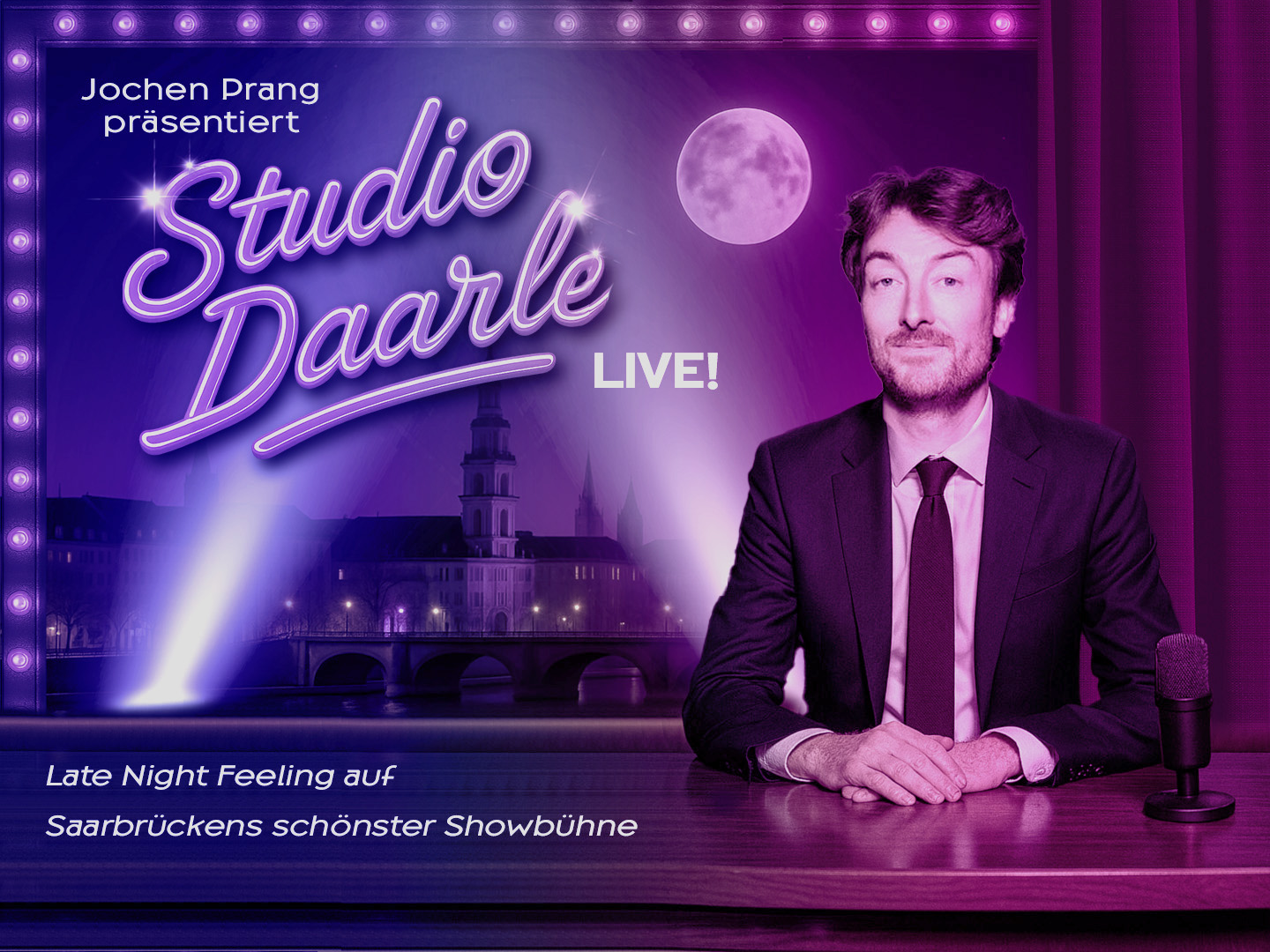Ein Mann sitzt an einem Tisch mit Mikrofon vor einer beleuchteten Bühne für die Veranstaltung Studio Daarle Live.
