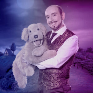 Zauberkünstler hält einen Plüschhund in den Armen und lächelt in die Kamera.