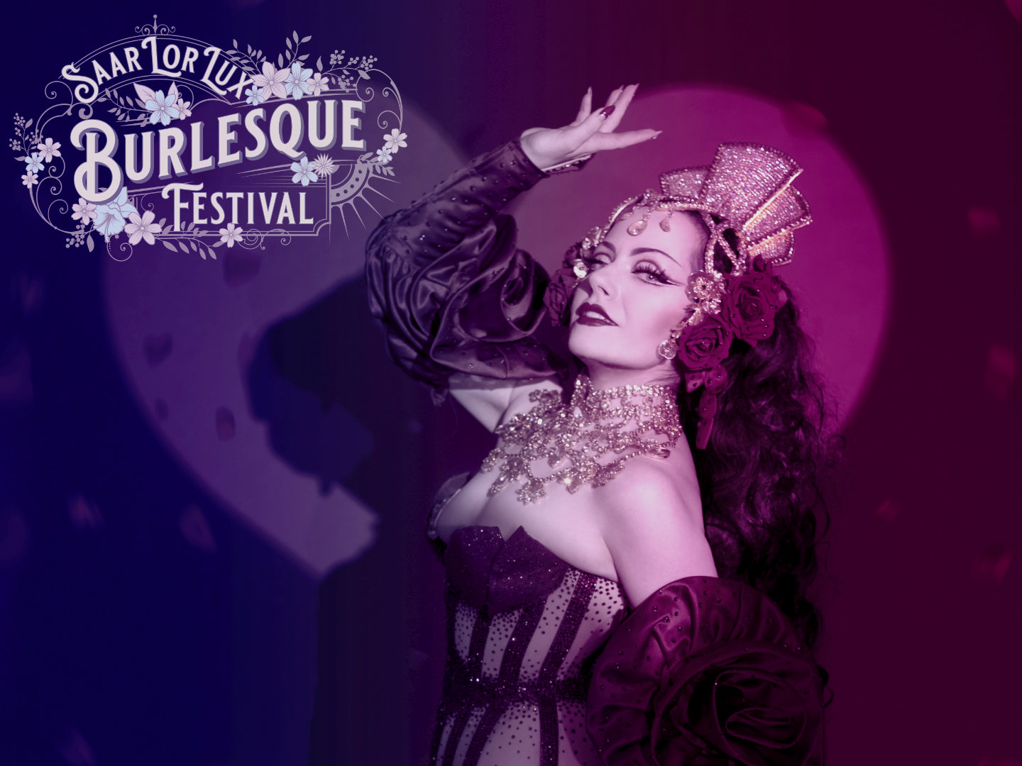 Eine Frau in einem Burlesque-Kostüm mit Schmuck und Blumen im Haar während einer Aufführung.