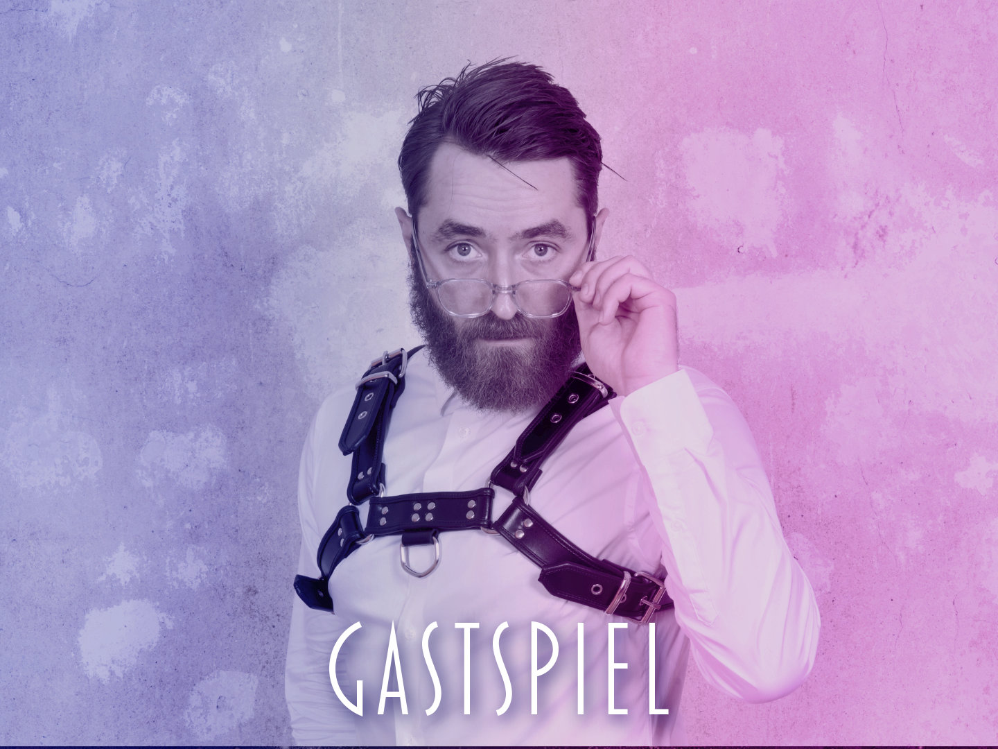 Mann mit Bart trägt eine Brille und ein schwarzes Geschirr über einem weißen Hemd.