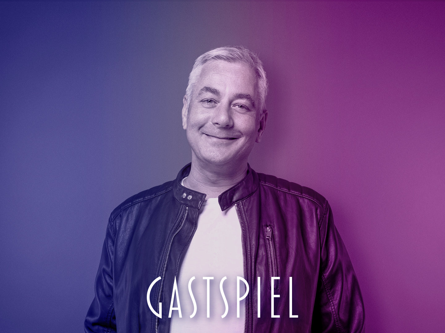 Porträt eines Mannes mit grauen Haaren in einer Lederjacke vor einem farbigen Hintergrund.